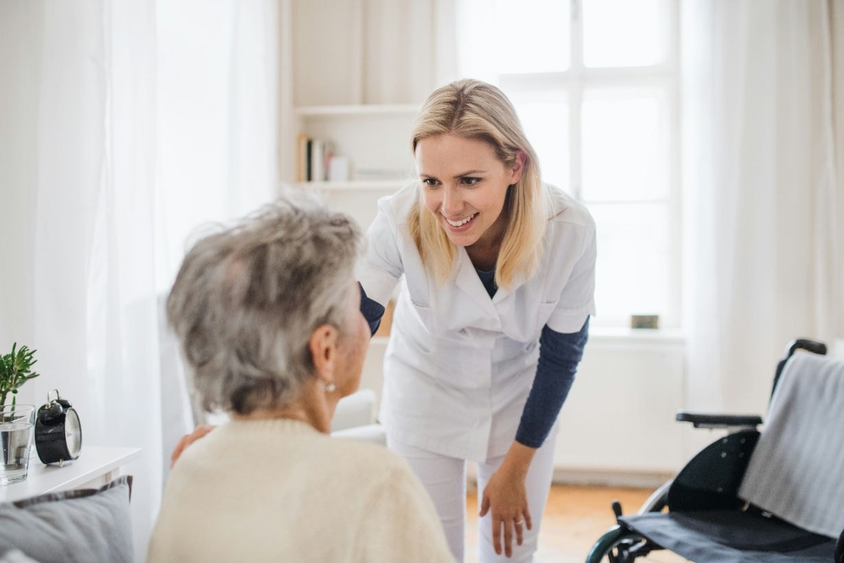 Senior disabled lady being comforted by caregiver